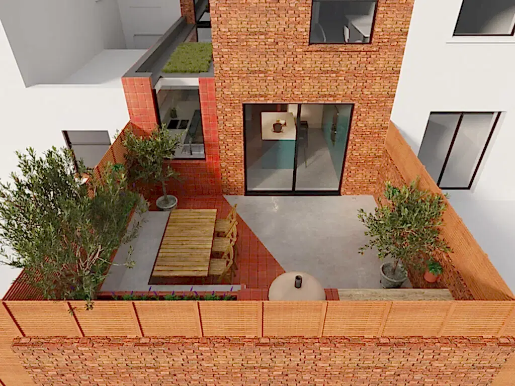 View of the rear extension and patio of Ice Cream House, the polished concrete floor continues from inside to outside with the seating area of the patio being tiled in terracotta tiles that wrap up the face of the side extension
