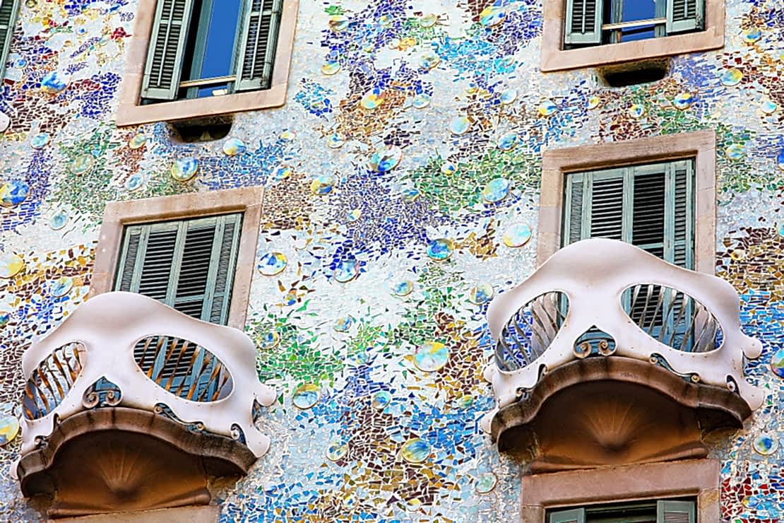 Decorative Gaudí-style balconies on a colourful mosaic façade in Barcelona, showing how balconies blend art, passive cooling, natural shading and urban character, illustrating the balance between architectural beauty, sustainability and community connection in Mediterranean design.