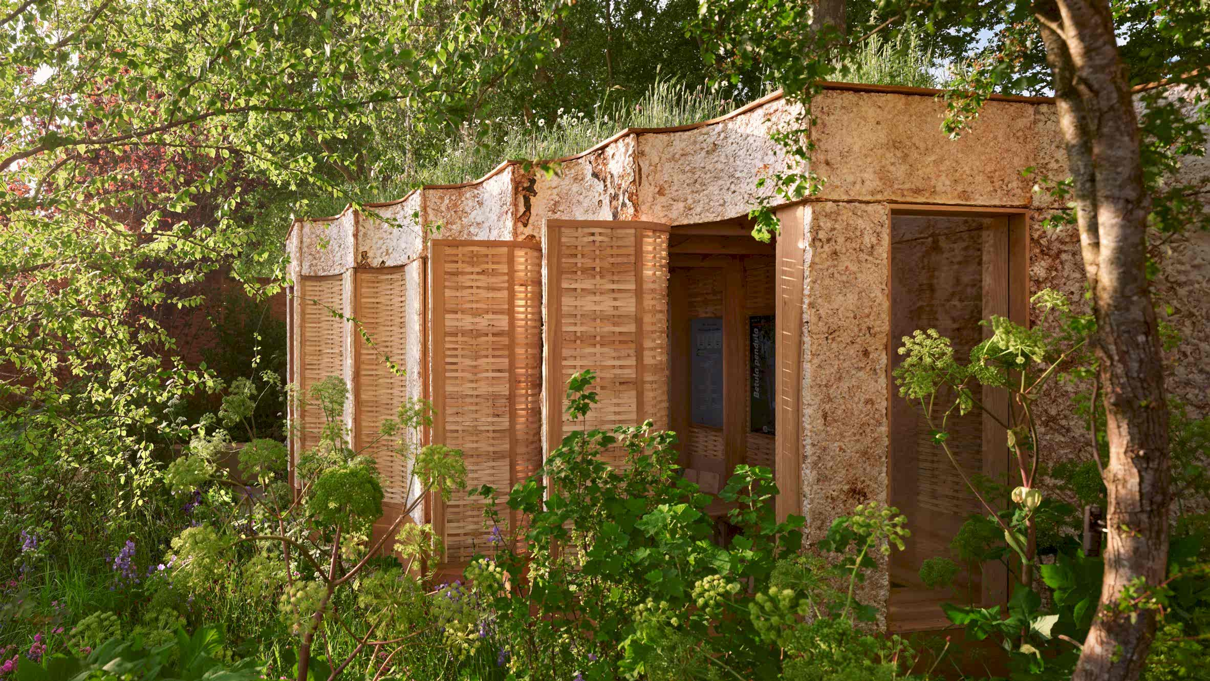 Exterior view of the Intelligent Garden pavilion at Chelsea Flower Show, designed by Studio Weave with Tom Massey and Sebastian Cox, featuring a fluted mycelium facade, woven ash panels and lush planting that inspires RISE Design Studio’s sustainable architecture.