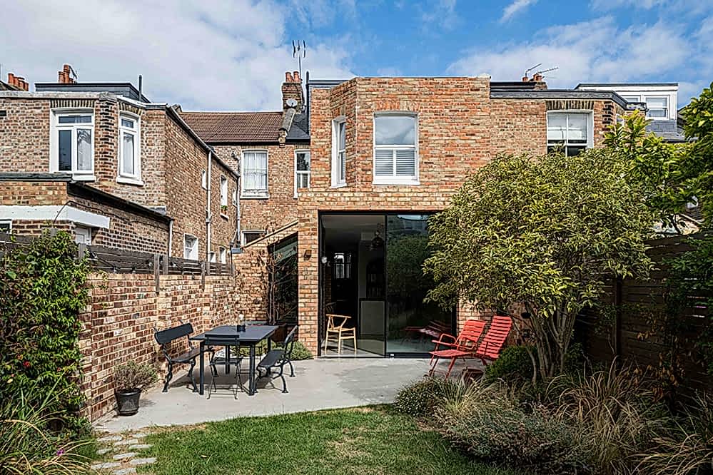 Sustainable 3-meter rear extension of a London home designed by RISE Design Studio, featuring reclaimed brick, large glazing for natural light, and garden integration.
