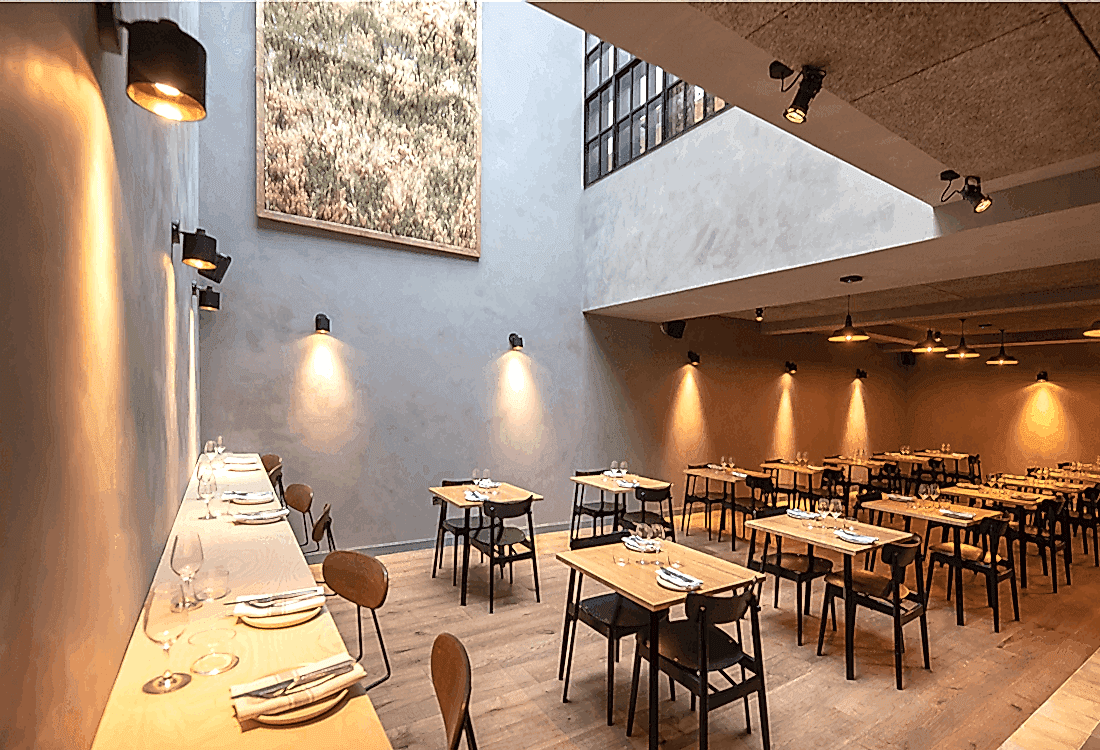 Modern dining space with minimalist design, natural lighting, and thoughtfully spaced tables, showcasing how cultural venues have adapted to post-pandemic priorities of comfort, safety, and aesthetic innovation.