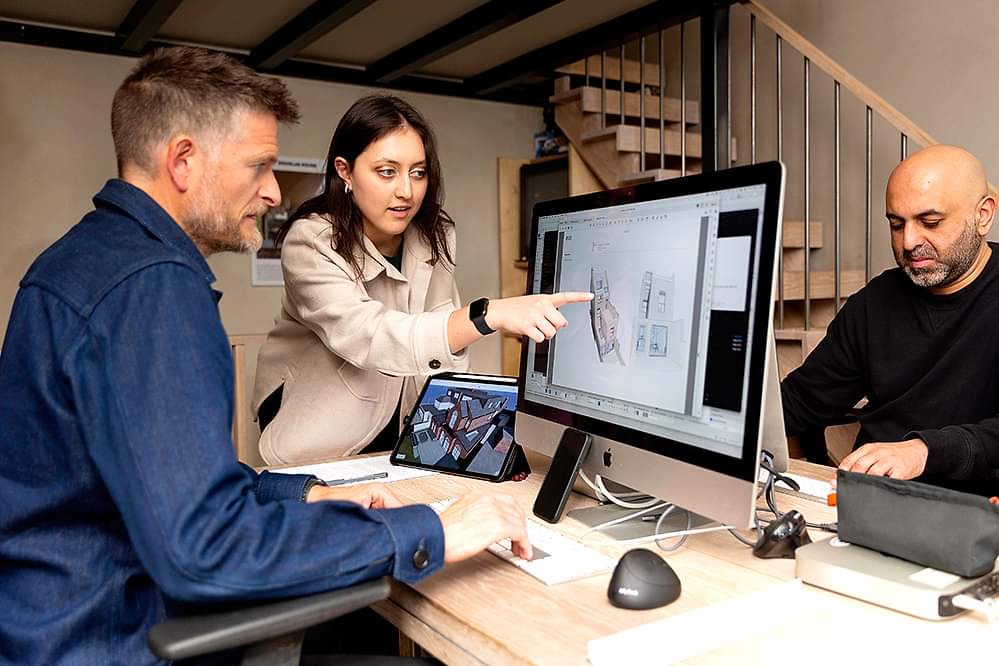 Architects and clients at RISE Design Studio review a 3D architectural model using BIMx software on desktop and tablet, enabling immersive collaboration, real-time feedback, and clarity throughout the design process.