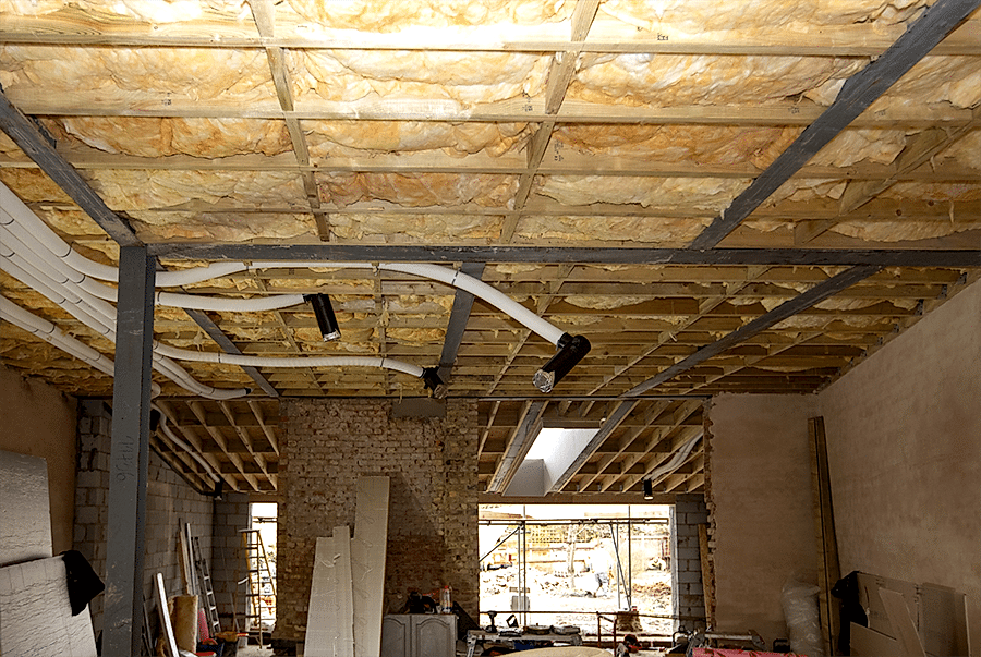 Exposed ceiling during retrofit by RISE Design Studio showing installed insulation and ventilation ductwork, designed to reduce overheating and improve indoor air quality as part of a sustainable, climate-resilient home upgrade.